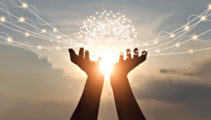 Hands raised towards a glowing network orb in the sky