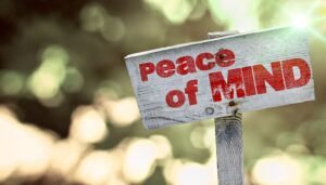 Wooden sign with 'Peace of Mind' outdoors