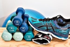 Fitness equipment with dumbbells, running shoe, and boxing gloves