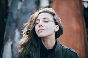 Woman with closed eyes enjoying the breeze outdoors