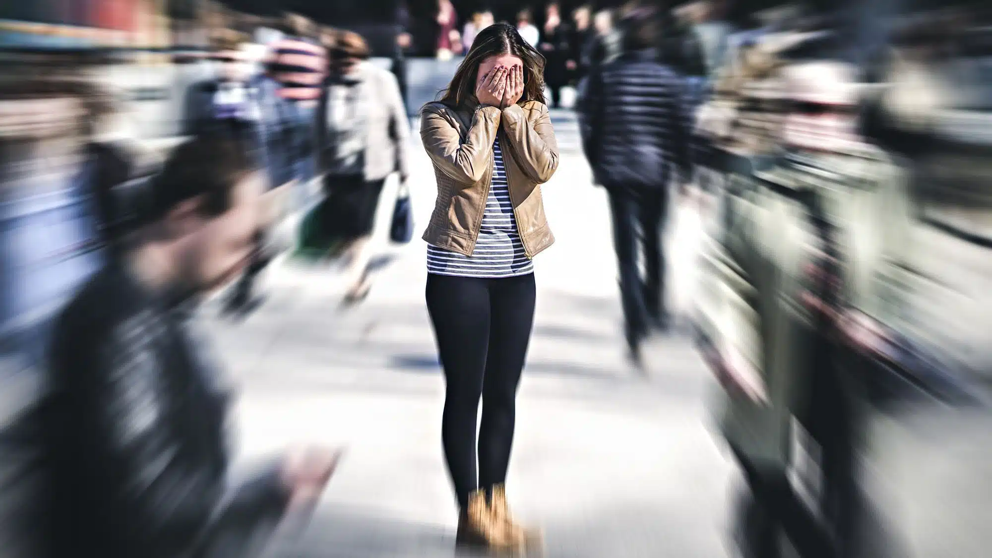 Woman overwhelmed in a blurred crowd, symbolizing stress or anxiety