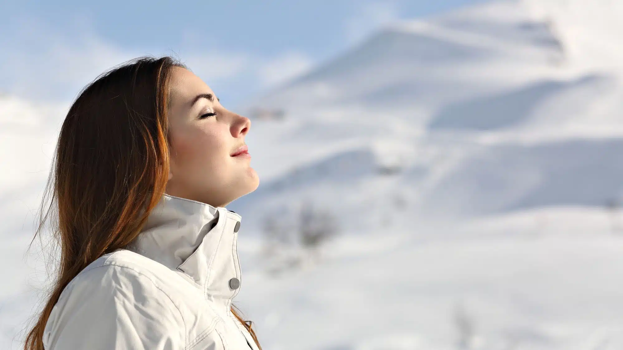 Woman enjoying fresh air in snowy mountain landscape