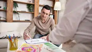 Man sketching interior design concept with materials and colour samples