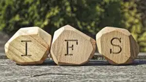 Wooden blocks with letters IFS on a rustic table