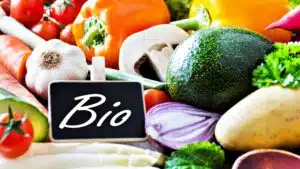 Assorted organic vegetables with chalkboard sign reading 'Bio'