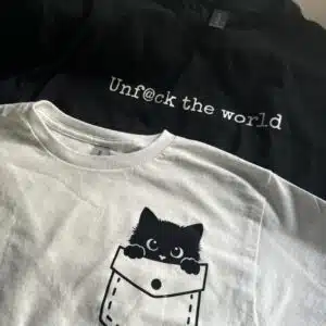 Black shirt with text and white shirt with cat in pocket design