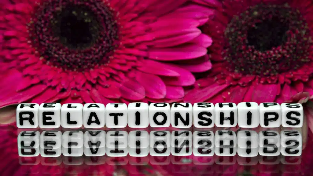 Letters spelling 'Relationships' with pink flowers in the background