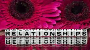 Letters spelling 'Relationships' with pink flowers in the background