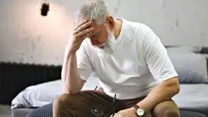 Elderly man seated and appearing deep in thought