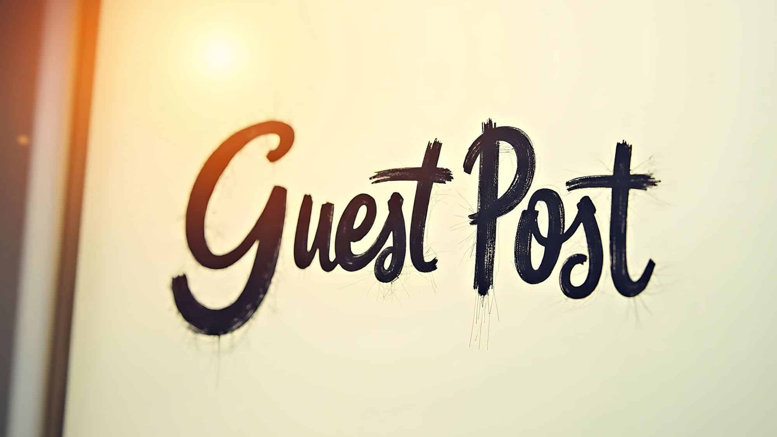 Stylized 'Guest Post' text on a sunlit wall