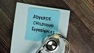 Adverse Childhood Experiences note with stethoscope on wooden desk