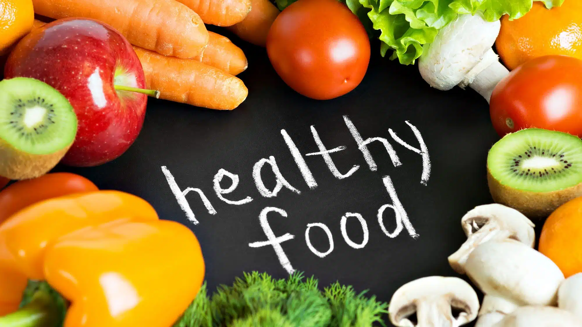 Assorted fresh fruits and vegetables encircling 'healthy food' text