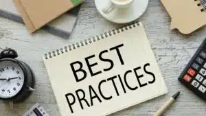 Notebook with 'Best Practices' on desk with office supplies