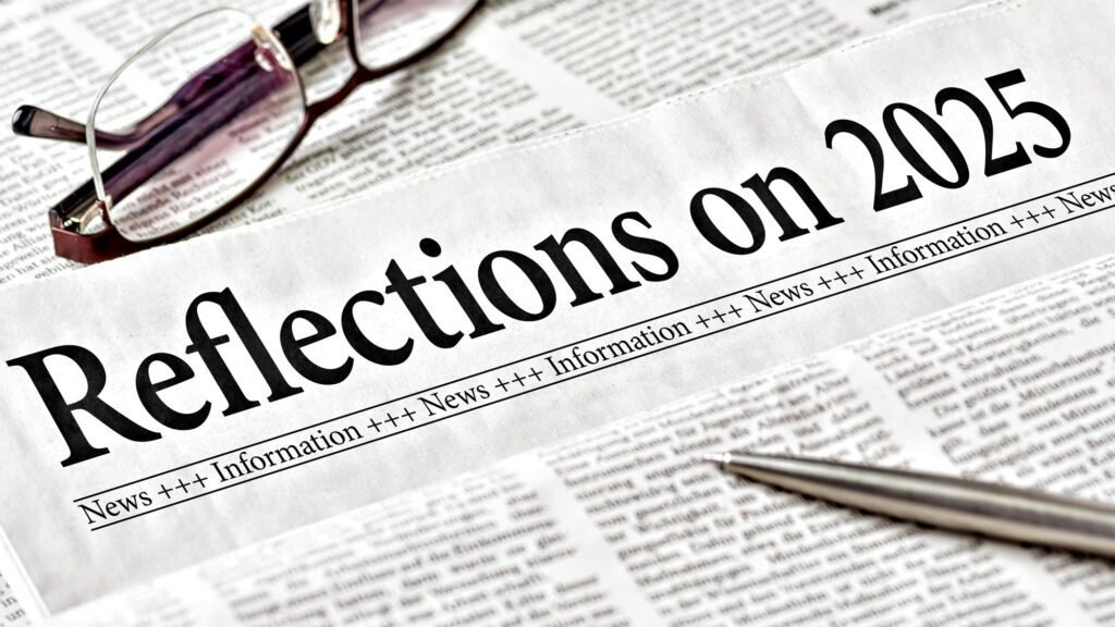 Newspaper headlined 'Reflections on 2025' with glasses and pen on newsprint
