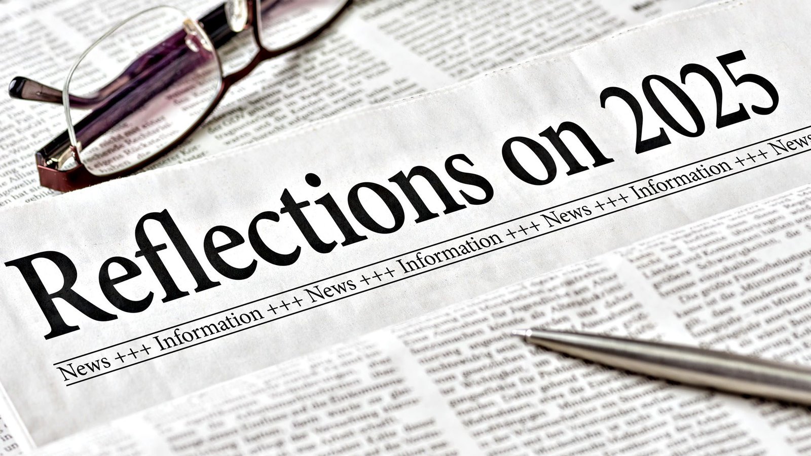 Newspaper headlined 'Reflections on 2025' with glasses and pen on newsprint