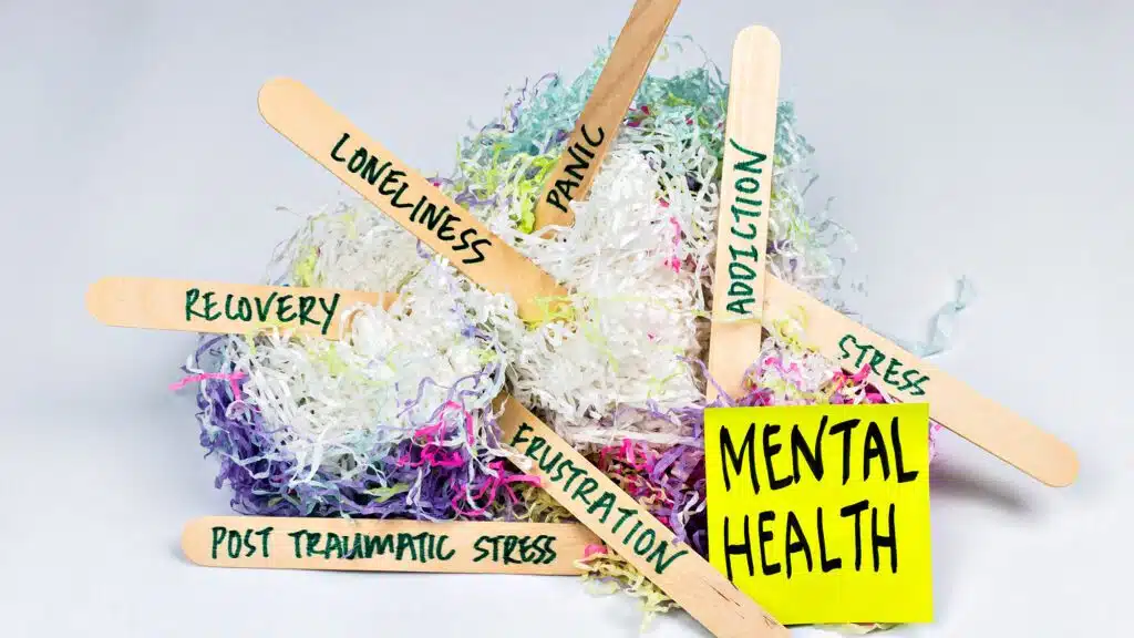 Mental health concept with labeled craft sticks and shredded paper