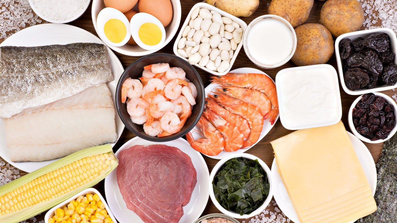 Assortment of high protein foods including fish, shrimp, eggs, and beans