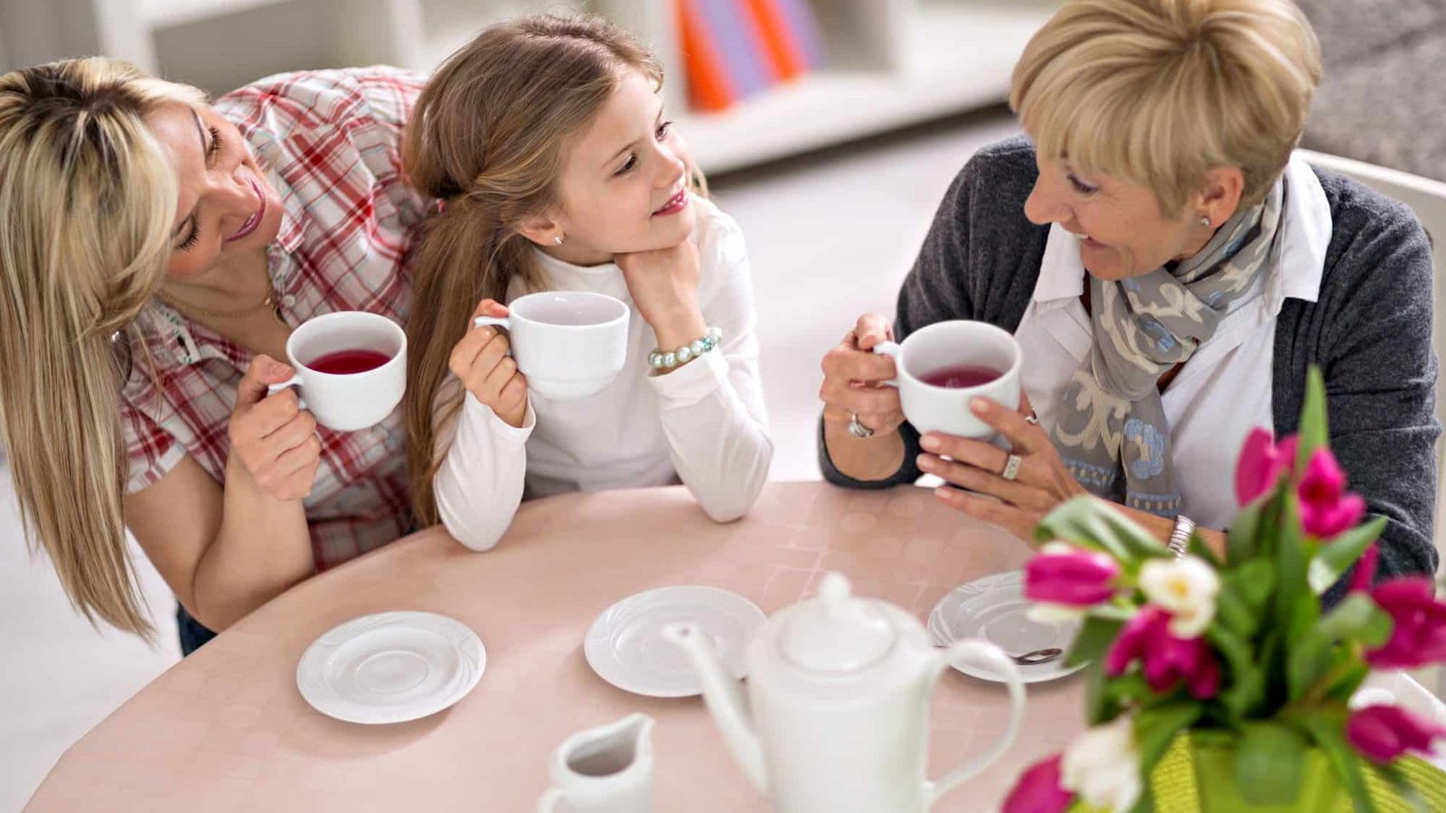 Three generations of women enjoying tea together at home