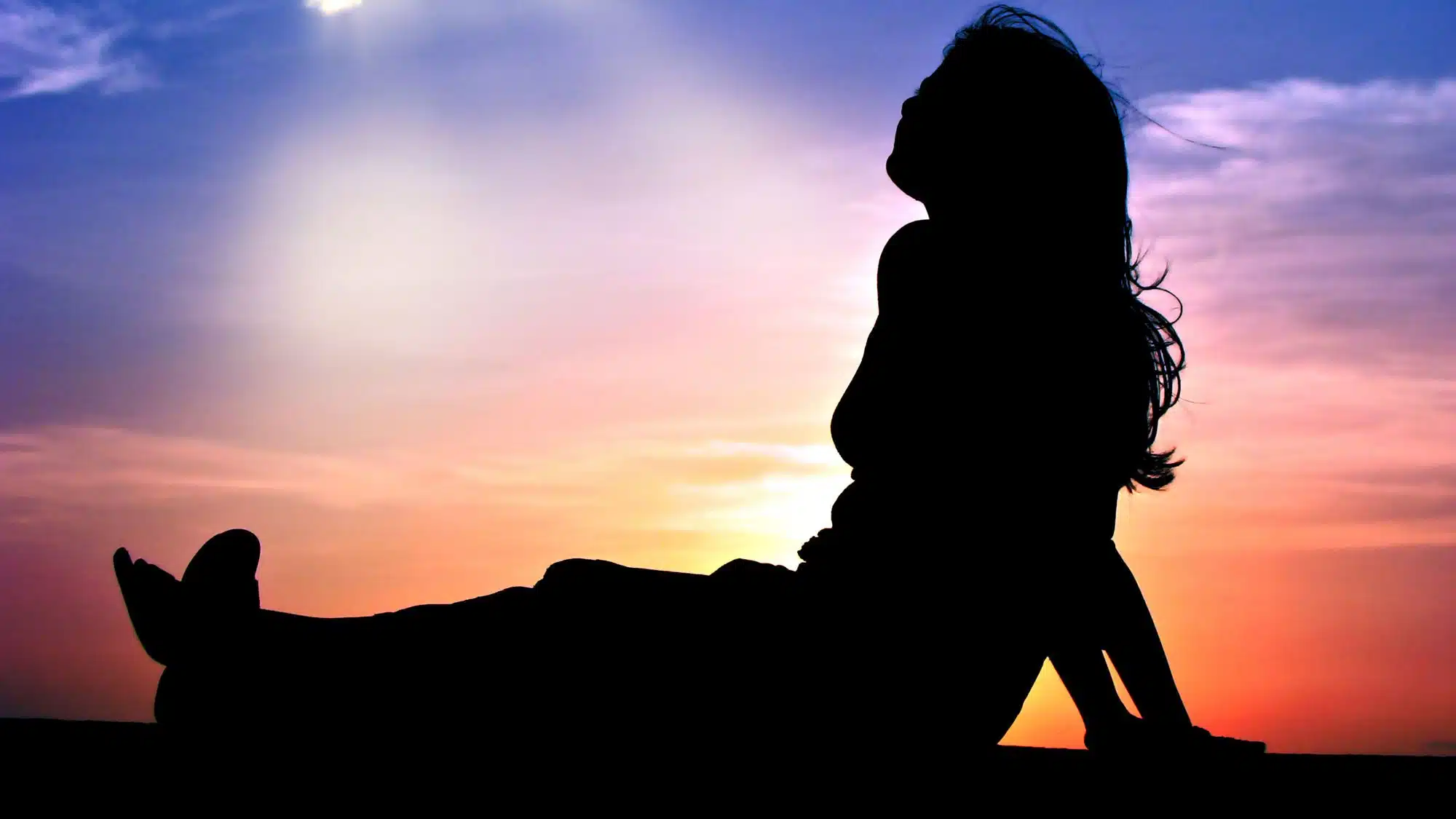 Silhouette of a person relaxing at sunset on the beach
