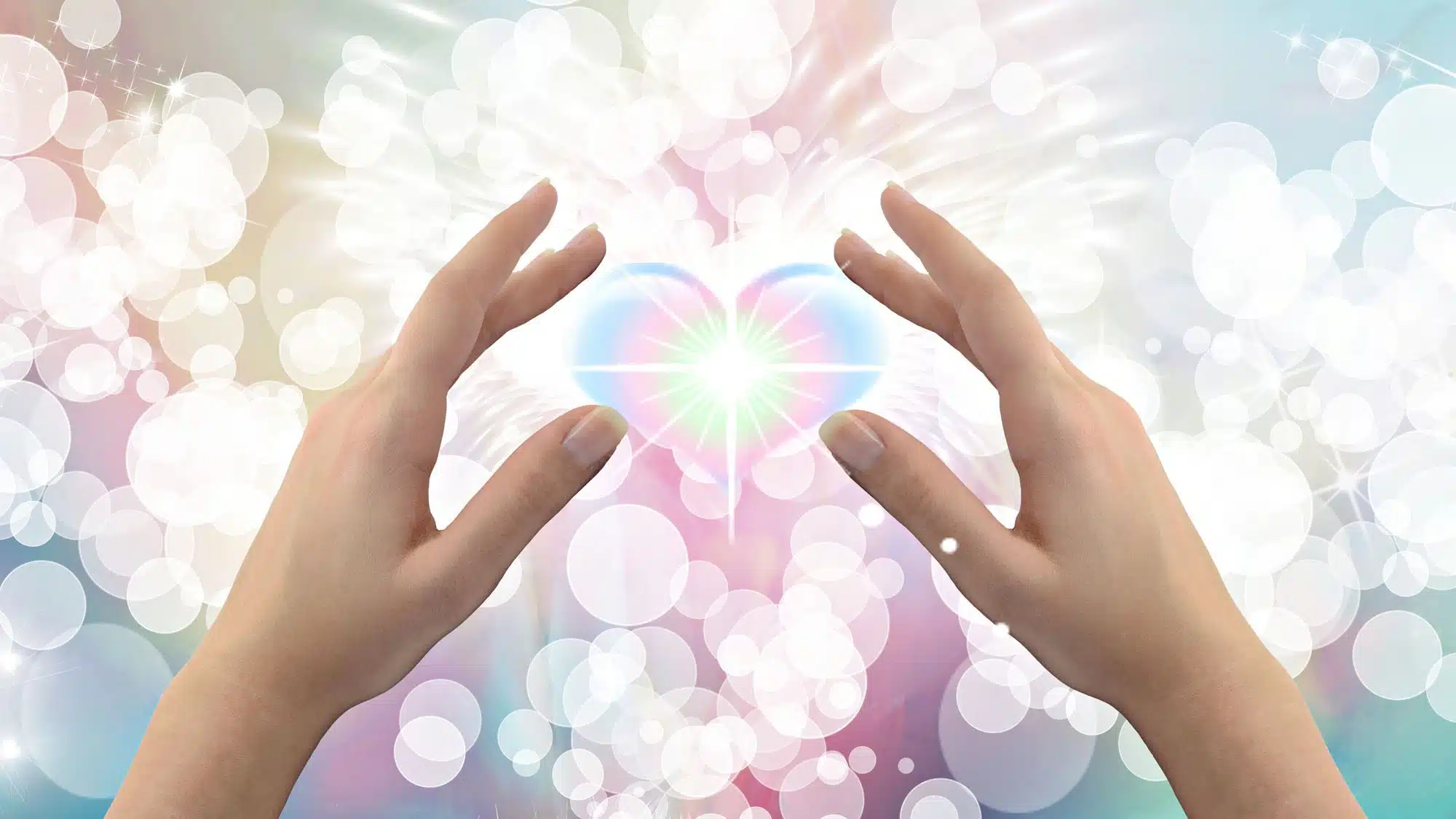 Hands shaping light heart with ethereal bokeh background