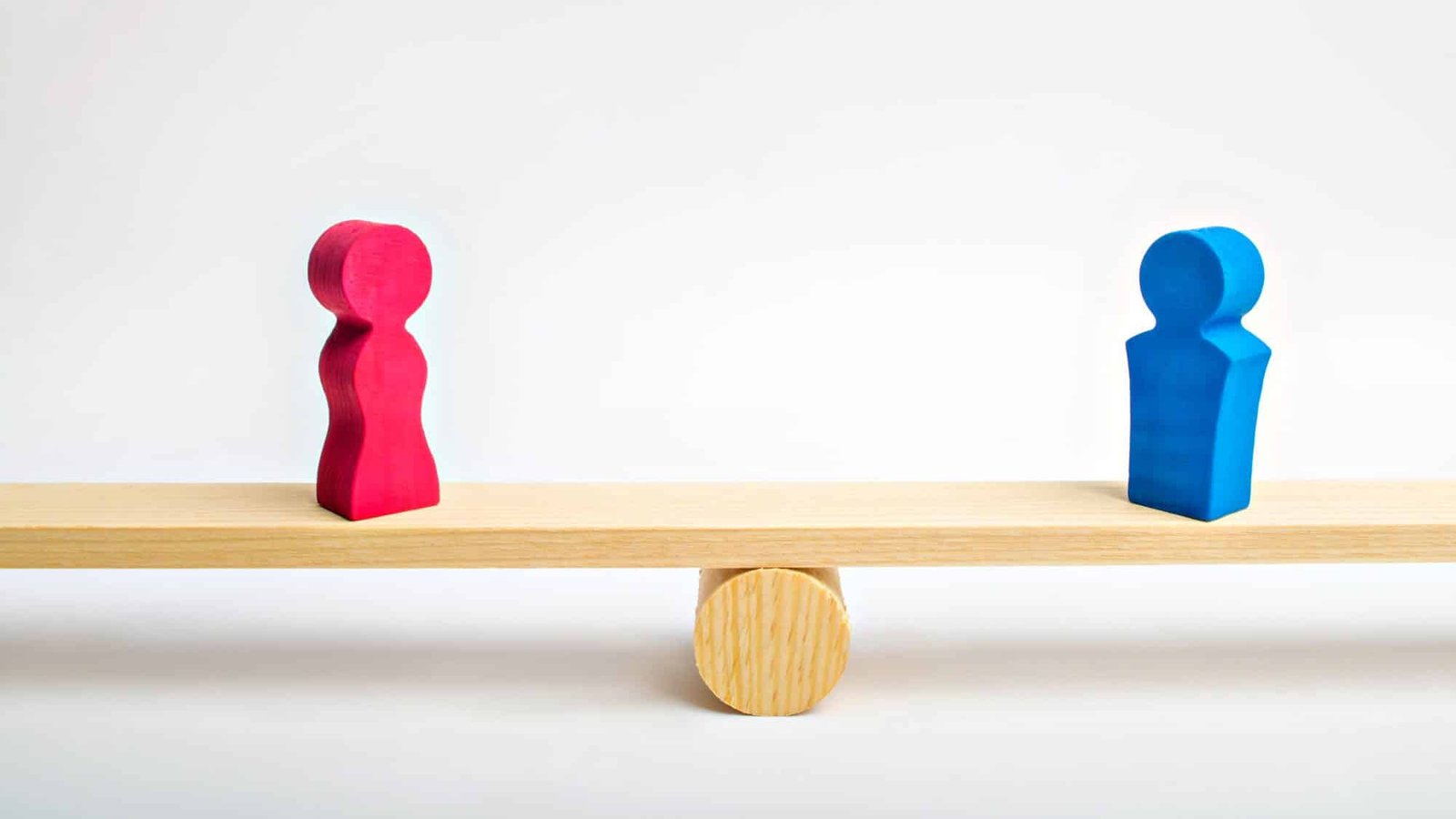 Gender balance concept with wooden figures on seesaw