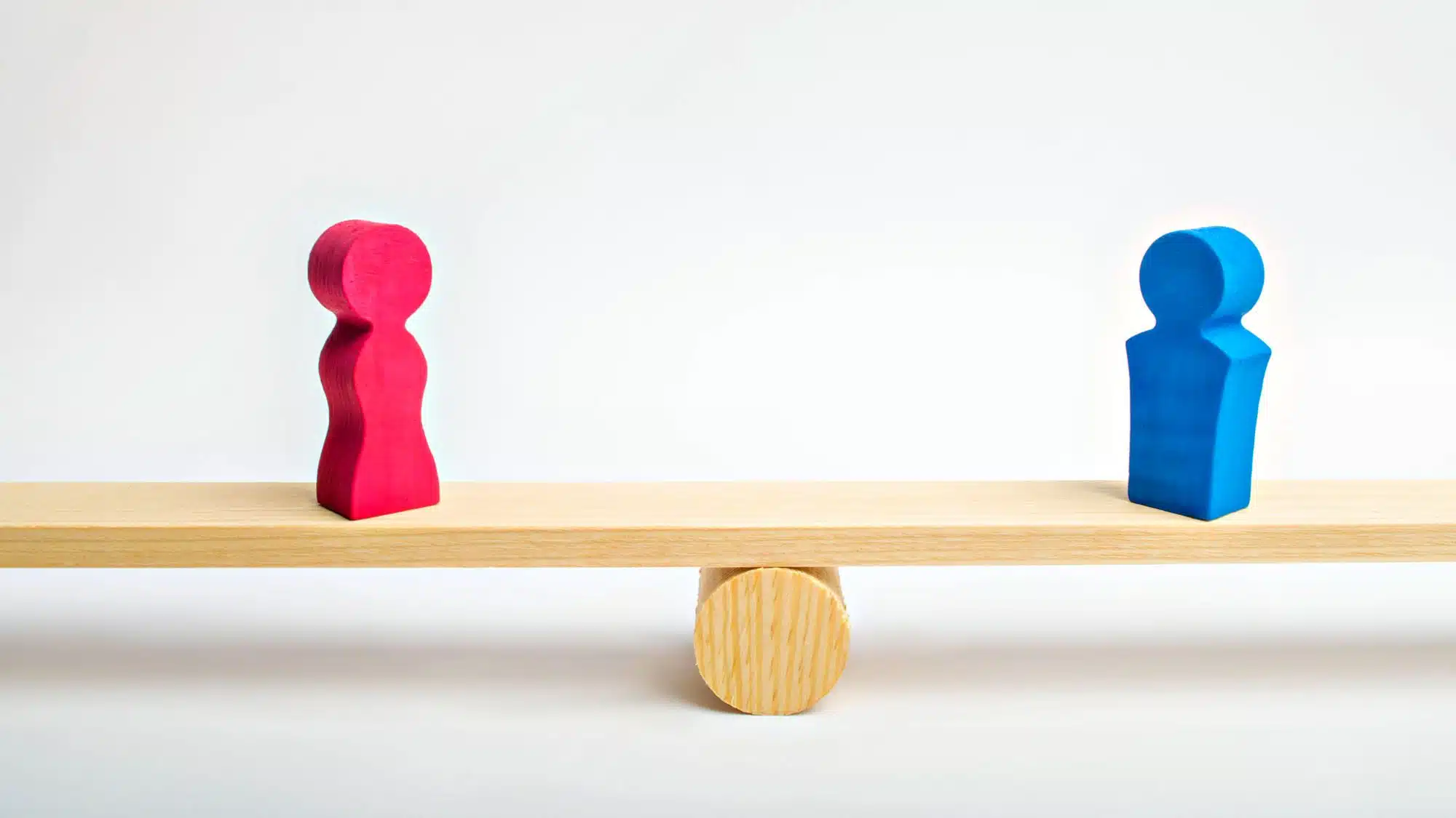 Gender balance concept with wooden figures on seesaw