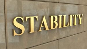 Golden word 'STABILITY' on stone wall background