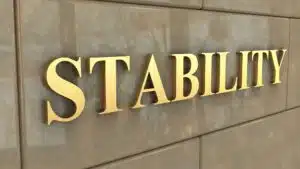 Golden word 'STABILITY' on stone wall background