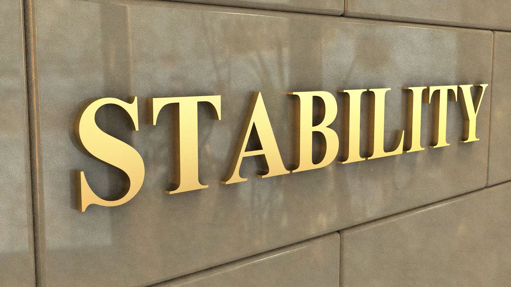 Golden word 'STABILITY' on stone wall background