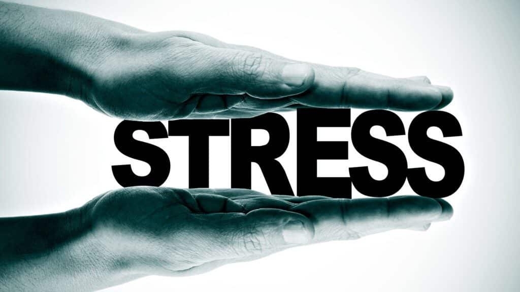 Hands pressing the word 'stress' representing stress management