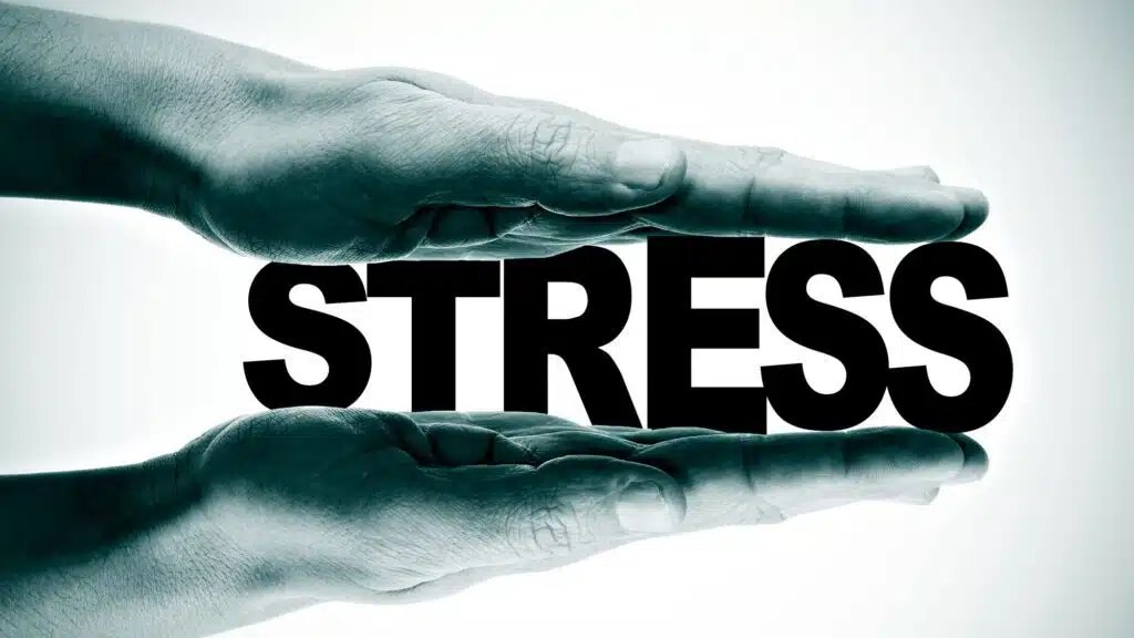 Hands pressing the word 'stress' representing stress management