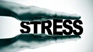 Hands pressing the word 'stress' representing stress management