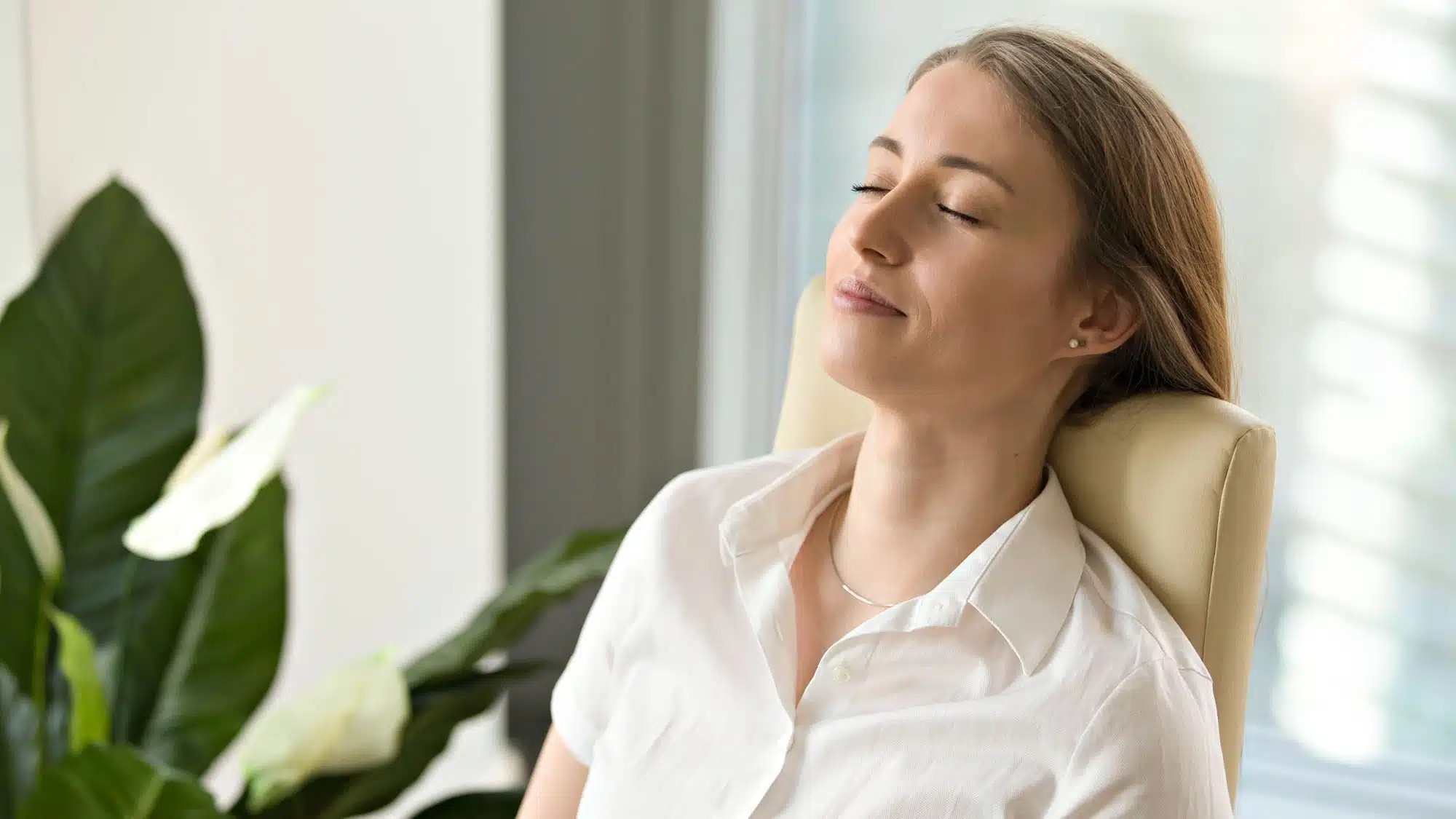 Woman relaxing with closed eyes in bright office