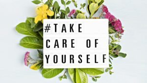 Self-care message on lightbox with leaves and flowers