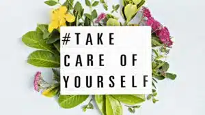 Self-care message on lightbox with leaves and flowers