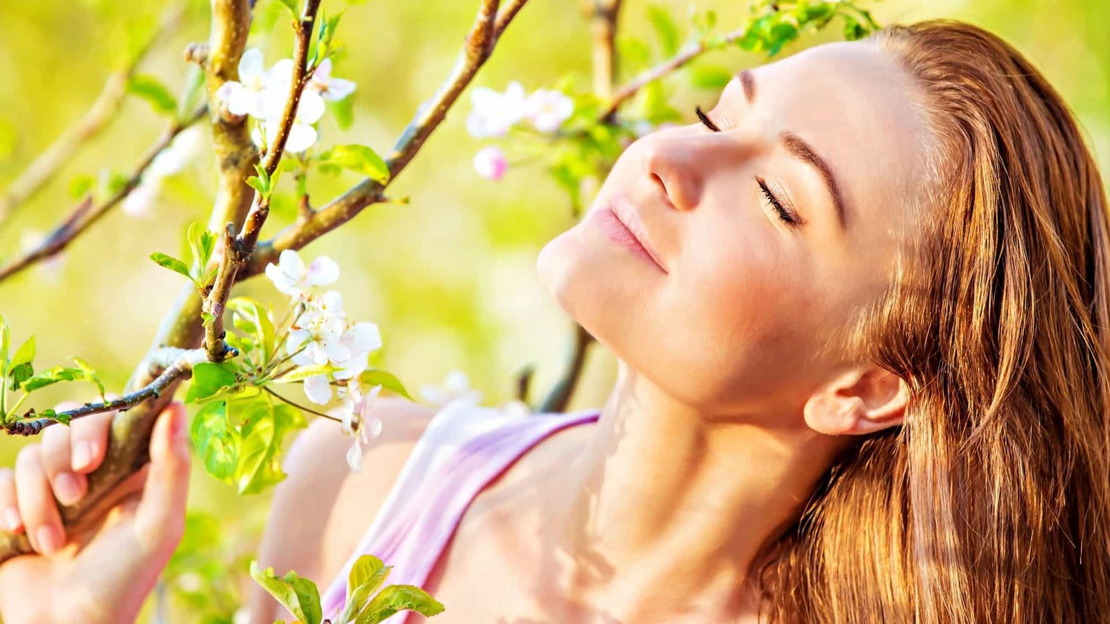 Woman enjoying spring blossoms in a sunny garden