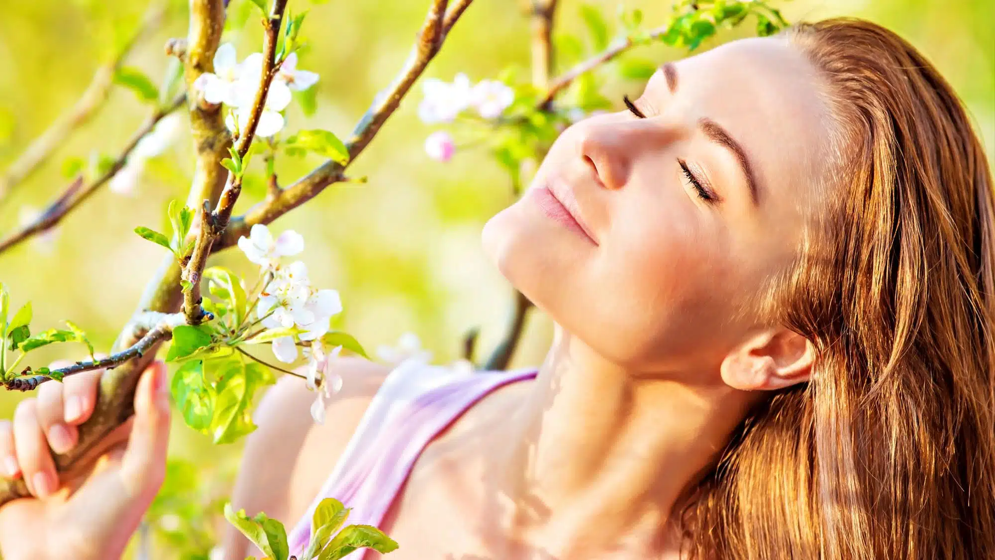 Woman enjoying spring blossoms in a sunny garden