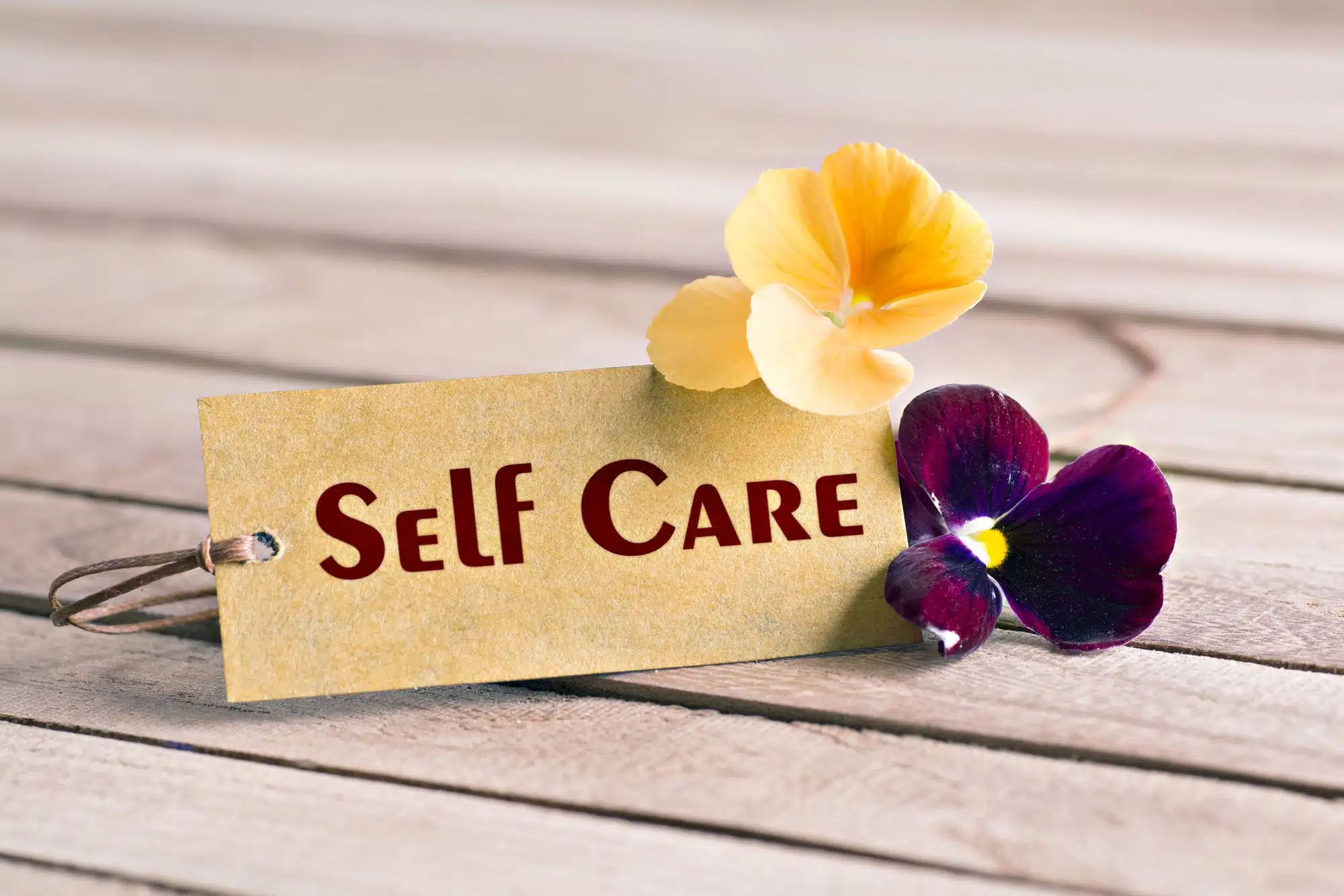 Self care concept with flowers and wooden background