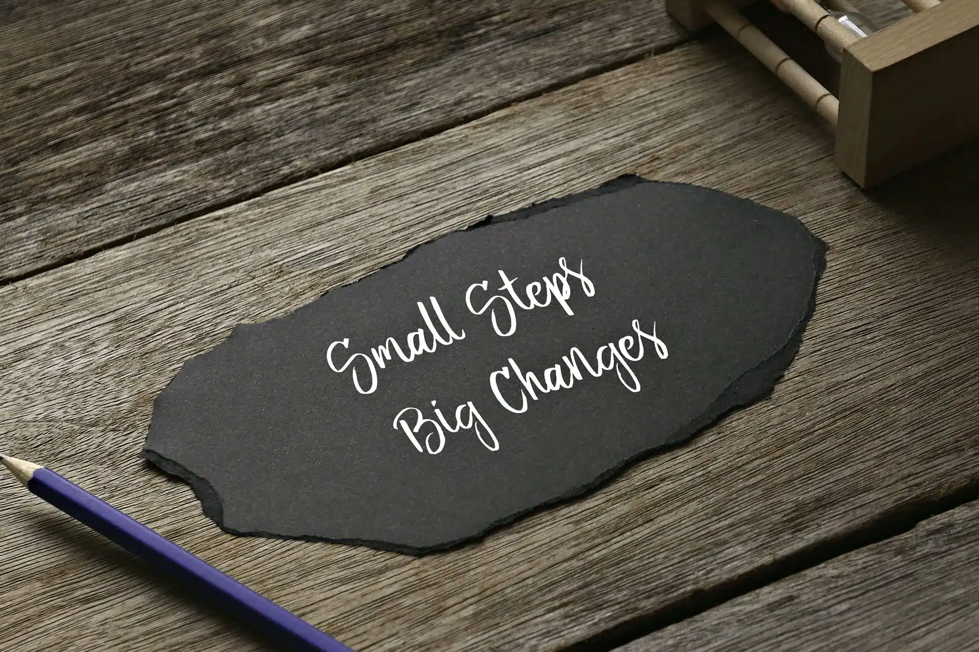 Motivational message 'Small Steps Big Changes' on rustic wood