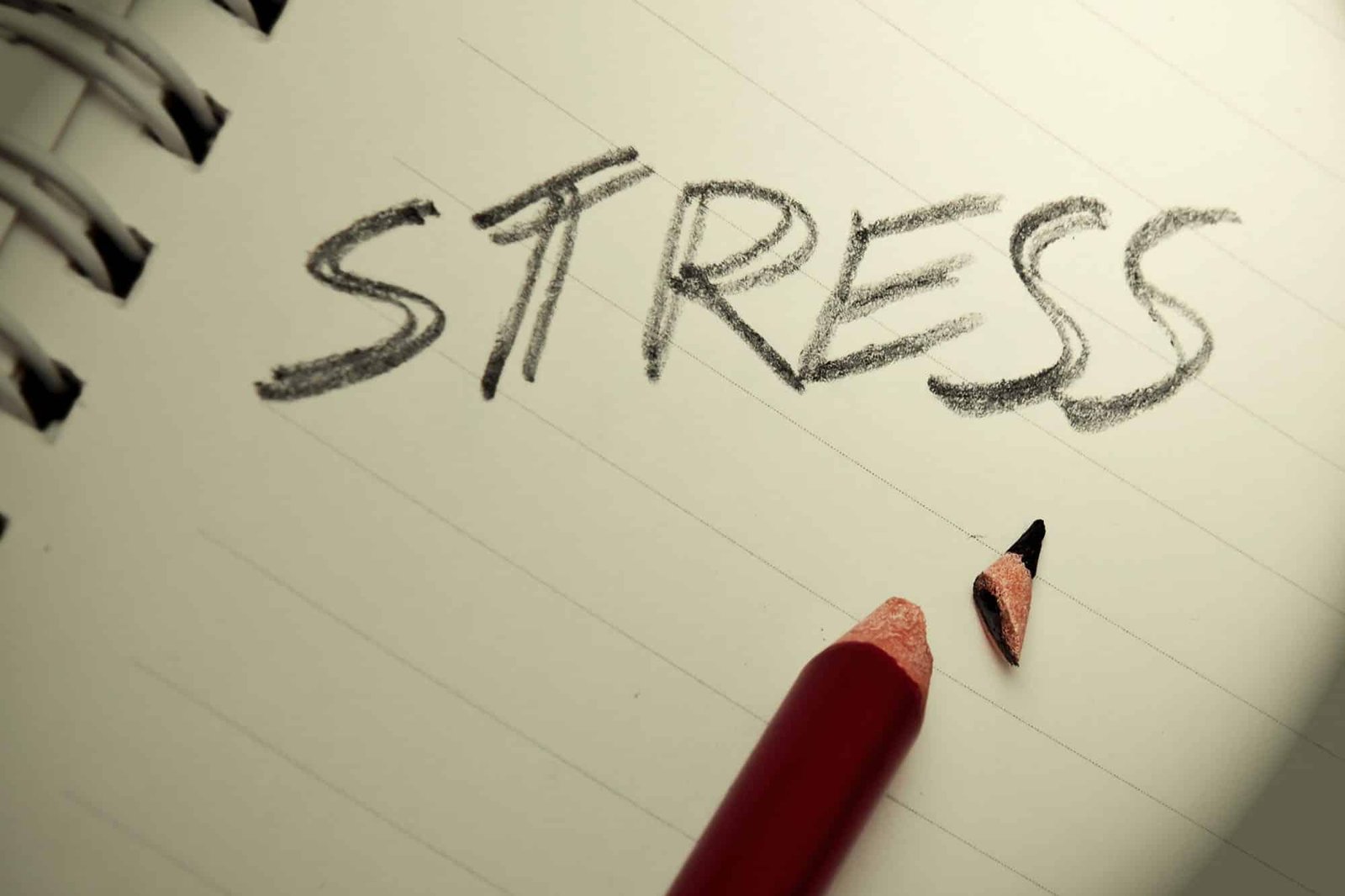 Stress concept with broken pencil next to the word stress on paper