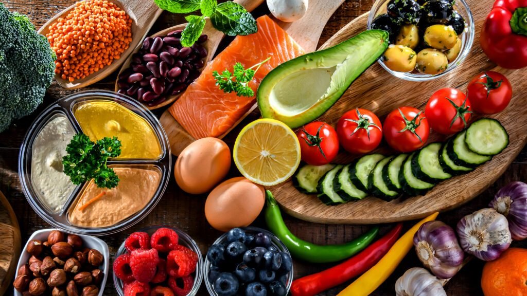 Healthy Mediterranean diet ingredients on the table including salmon, avocado, and fresh vegetables