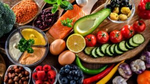 Healthy Mediterranean diet ingredients on the table including salmon, avocado, and fresh vegetables