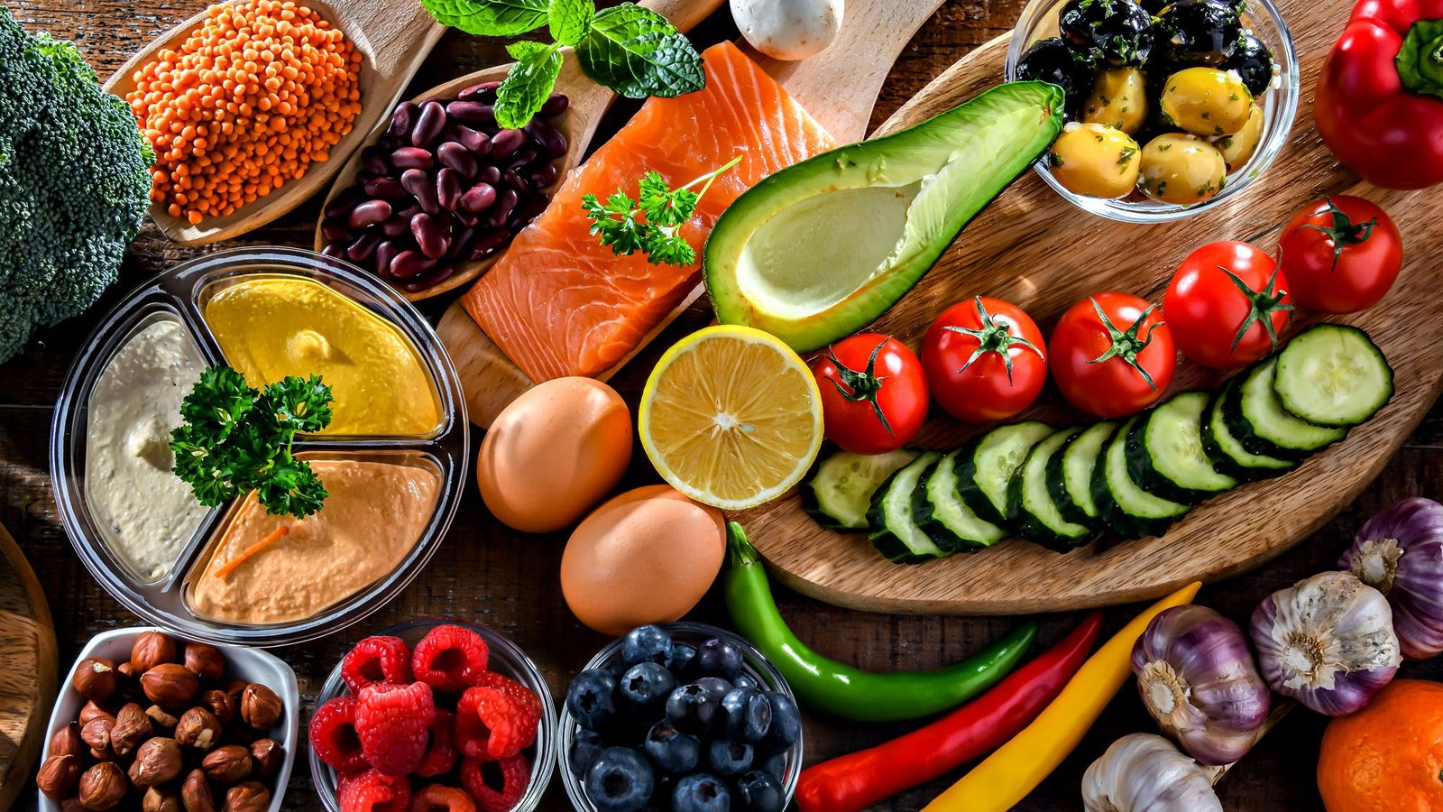 Healthy Mediterranean diet ingredients on the table including salmon, avocado, and fresh vegetables