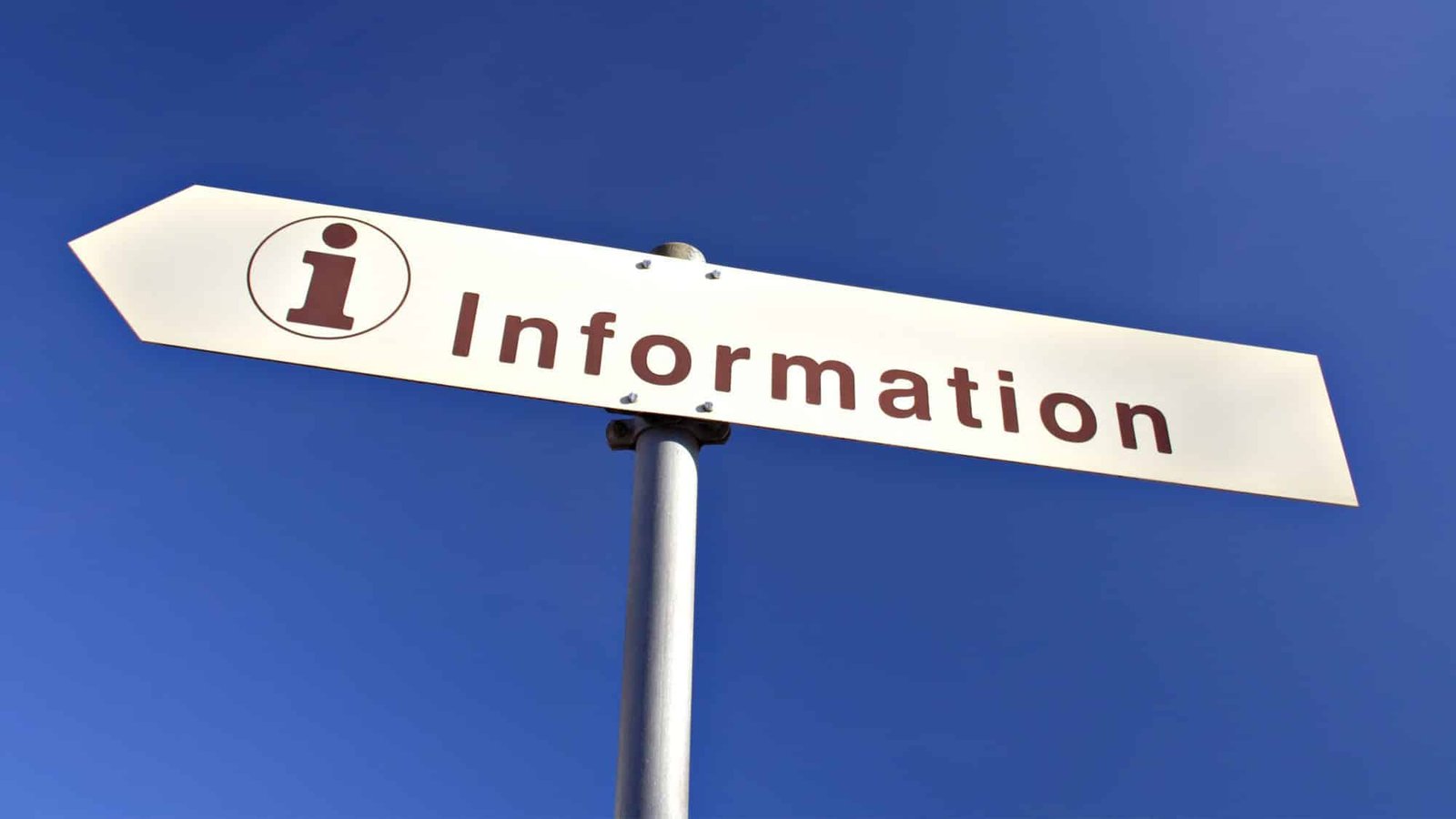 Information signpost against clear blue sky